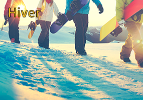 Colonies de vacances hiver, 4 jeunes sur la neige avec des snows et des skis au sports d'hiver, soleil couchant derrière